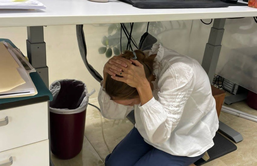 A Governor's Office staff member carries out the drop, cover and hold safety technique in the October 16 ShakeOut exercise